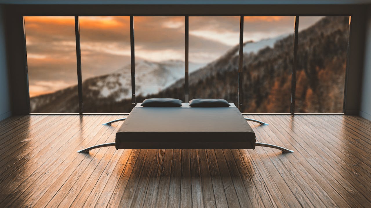 why-choose-us-01 Minimalist bedroom with large windows offering a breathtaking mountain view during sunset.